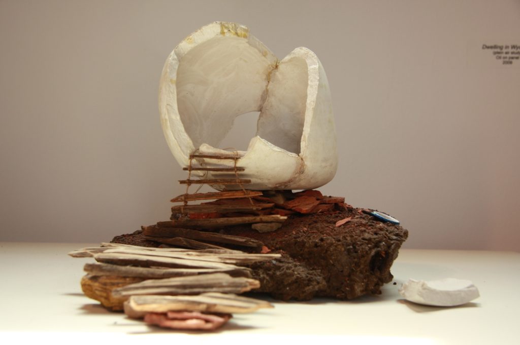 Melanie Vote: Head as Home (2010), maquette: unfired porcelain, cow pie, wood, other found materials, 10x10x12 in.